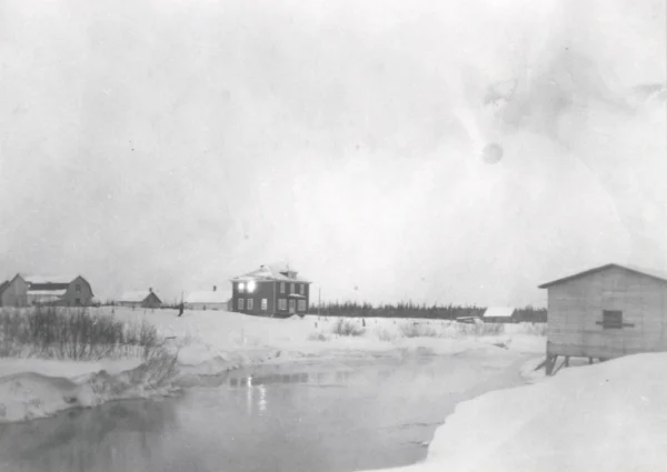 1927 — église — Tags: église, rivière — Le presbytère avant la construction de l\'église, 1927.  A droite boutique de forge, ensuite salle de cinéma, shop Armand Lemieux